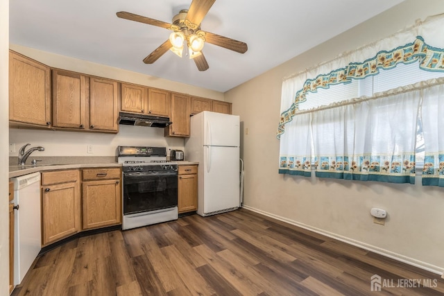 kitchen with white appliances, brown cabinetry, dark wood-style floors, light countertops, and under cabinet range hood