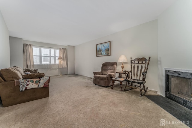 living room with carpet floors and a fireplace with flush hearth