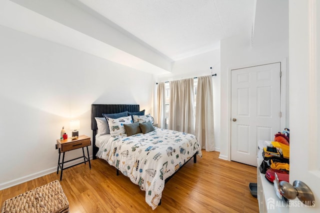 bedroom with light wood finished floors and baseboards