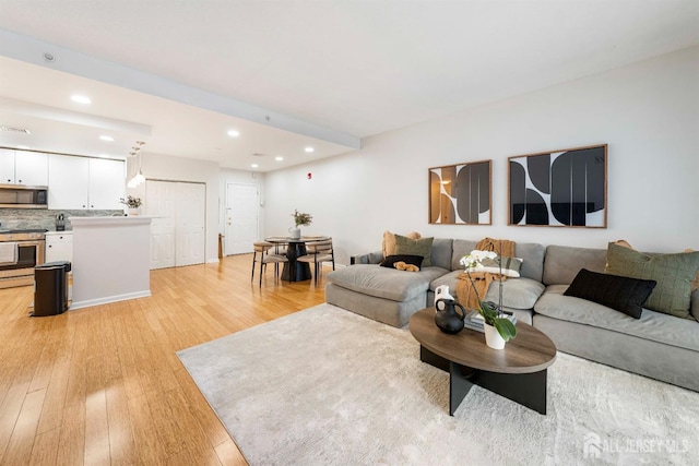 living area with recessed lighting and light wood-style floors
