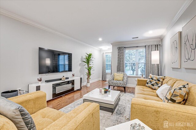 living room featuring light wood-type flooring and crown molding