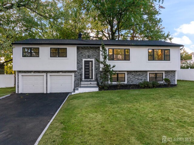 bi-level home with a garage and a front yard