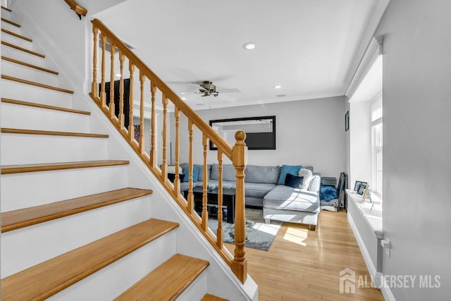 stairs featuring recessed lighting, wood finished floors, a ceiling fan, baseboards, and crown molding