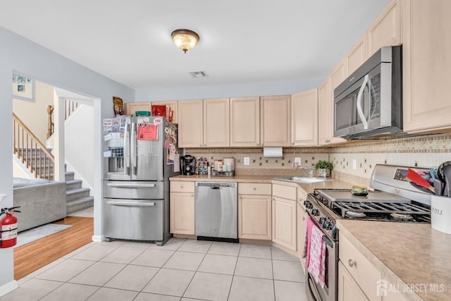 12 Jeremy Way, Old Bridge, NJ 08857 - kitchen featuring appliances with stainless steel finishes, light countertops, light brown cabinets, decorative backsplash, and a sink