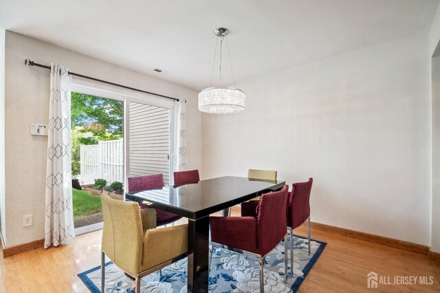 297 Kraemer Ct, East Brunswick, NJ 08816 - dining room with light wood finished floors, baseboards, and a chandelier