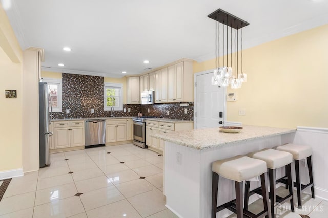 55 Nottingham Dr, Old Bridge, NJ 08857 - kitchen featuring appliances with stainless steel finishes, cream cabinets, a peninsula, backsplash, and ornamental molding