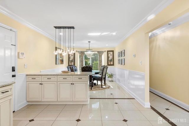 55 Nottingham Dr, Old Bridge, NJ 08857 - kitchen with light tile patterned floors, light stone counters, crown molding, hanging light fixtures, and wainscoting