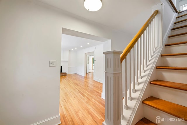 299 Riva Ave, East Brunswick, NJ 08850 - staircase with wood finished floors, a brick fireplace, and baseboards