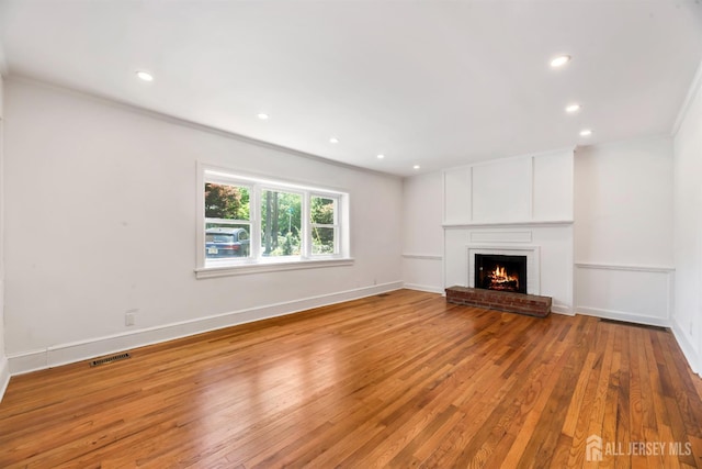 299 Riva Ave, East Brunswick, NJ 08850 - unfurnished living room featuring hardwood / wood-style floors, recessed lighting, a brick fireplace, baseboards, and crown molding