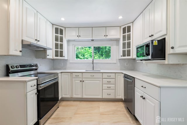 299 Riva Ave, East Brunswick, NJ 08850 - kitchen featuring appliances with stainless steel finishes, under cabinet range hood, a sink, decorative backsplash, and white cabinets