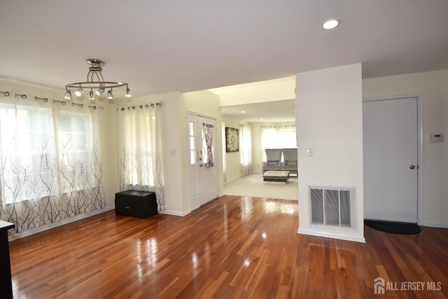 interior space featuring wood-type flooring, an inviting chandelier, and a wealth of natural light