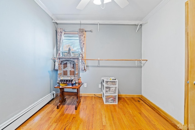 walk in closet with a baseboard radiator, wood finished floors, and ceiling fan