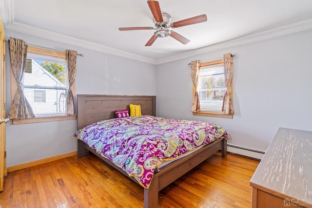 bedroom with baseboards, crown molding, ceiling fan, a baseboard radiator, and wood finished floors