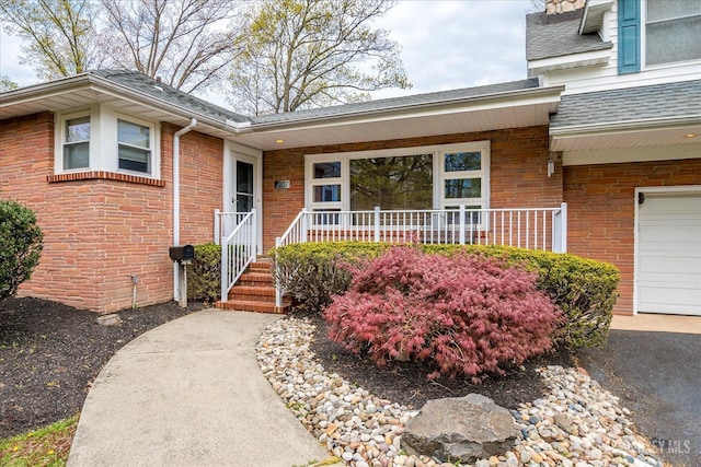 207 Dellwood Rd, Metuchen, NJ 08840 - entrance to property featuring a porch, a shingled roof, brick siding, and a garage