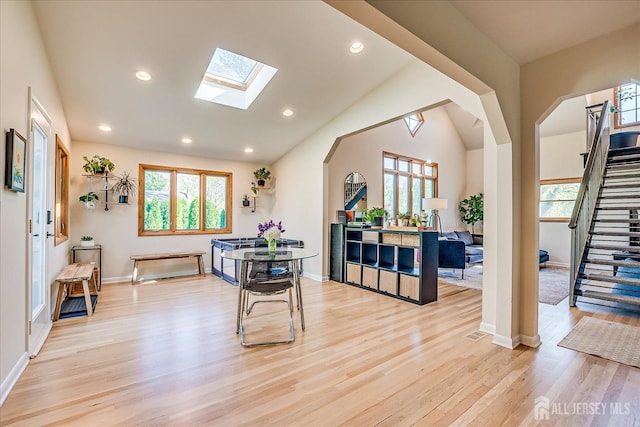 207 Dellwood Rd, Metuchen, NJ 08840 - dining space featuring light wood finished floors, a skylight, stairway, arched walkways, and lofted ceiling
