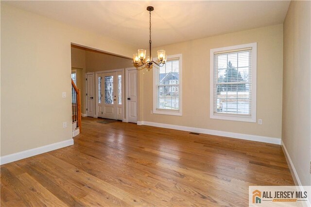 4 Kristina Ct, East Brunswick, NJ 08816 - spare room featuring a chandelier, wood finished floors, and baseboards
