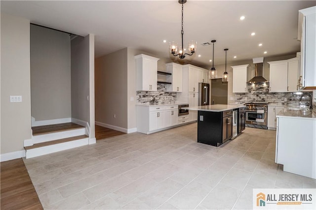 4 Kristina Ct, East Brunswick, NJ 08816 - kitchen with high quality appliances, light countertops, a chandelier, wall chimney range hood, and decorative backsplash