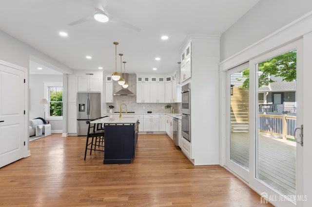 831 W Inman Ave, Rahway, NJ 07065 - kitchen featuring stainless steel appliances, wall chimney range hood, healthy amount of natural light, a breakfast bar area, and recessed lighting