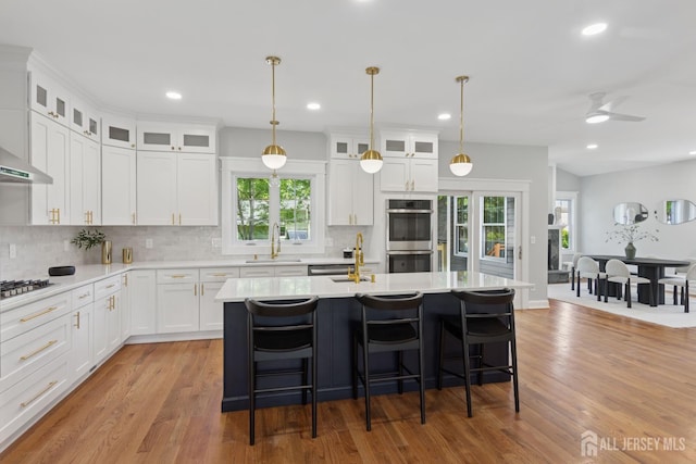 831 W Inman Ave, Rahway, NJ 07065 - kitchen featuring stainless steel double oven, light countertops, backsplash, light wood-type flooring, and recessed lighting