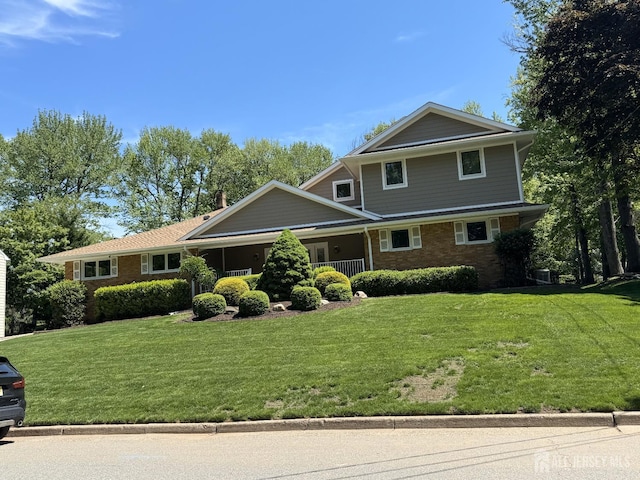 view of front of home with a front lawn and brick siding