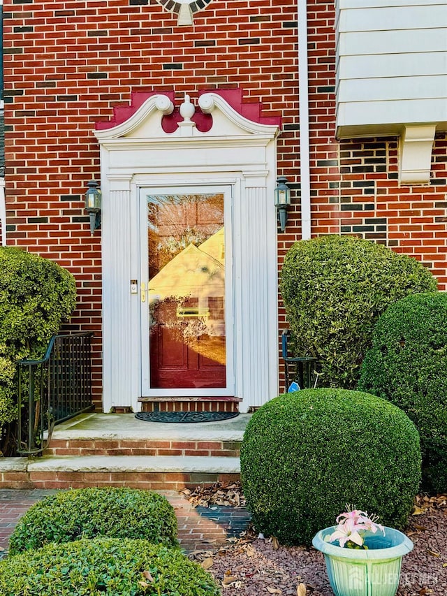 entrance to property featuring brick siding