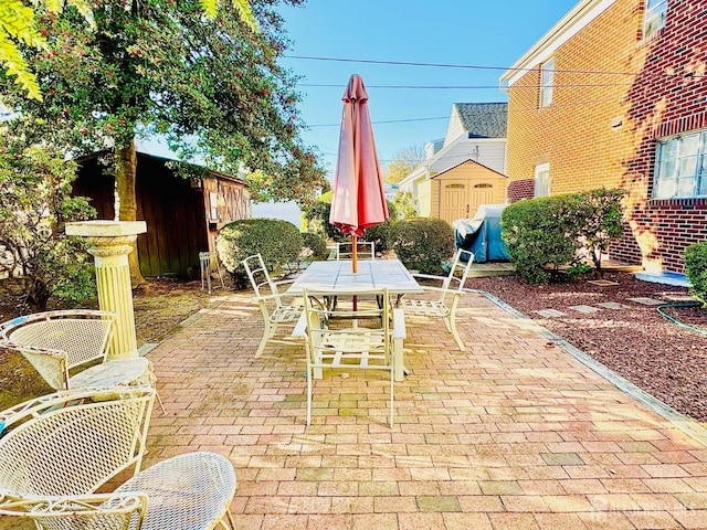 view of patio featuring an outbuilding and outdoor dining area