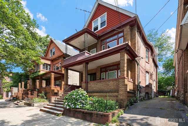 52 Wade St, Jersey City, NJ 07305 - view of front facade featuring brick siding, a porch, and a balcony