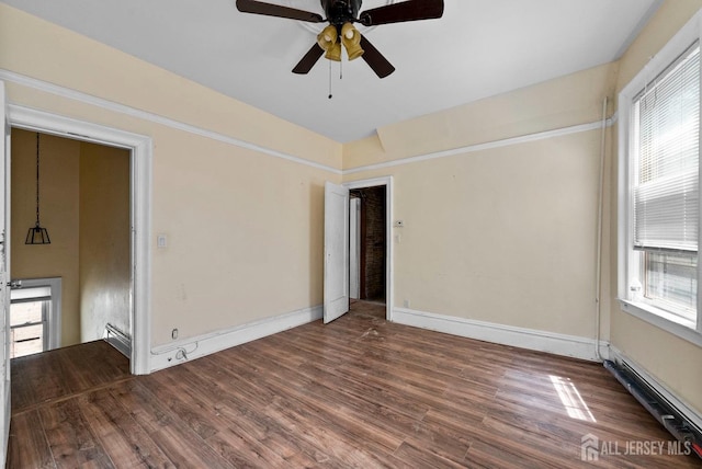 52 Wade St, Jersey City, NJ 07305 - unfurnished room with wood finished floors, plenty of natural light, ceiling fan, and a baseboard heating unit