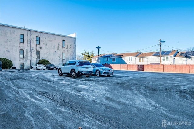 uncovered parking lot featuring fence