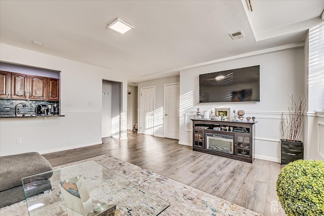 living area with wood finished floors and visible vents