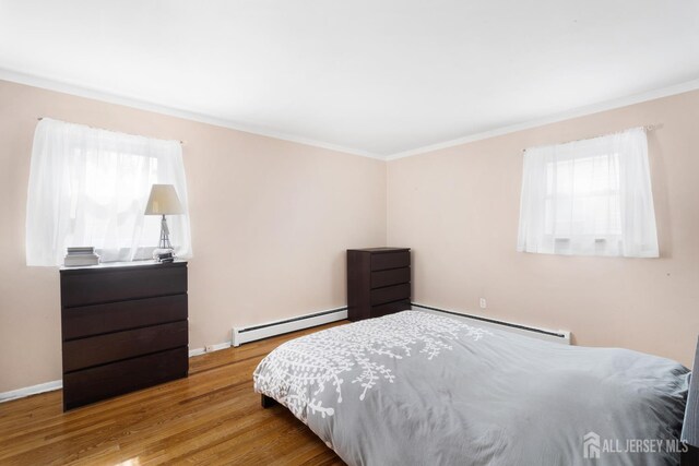 2001 Grant Ave, South Plainfield, NJ 07080 - bedroom with a baseboard heating unit, ornamental molding, multiple windows, and wood finished floors