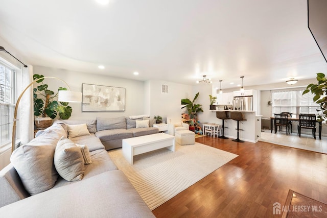 living area featuring a healthy amount of sunlight, light wood-type flooring, visible vents, and recessed lighting