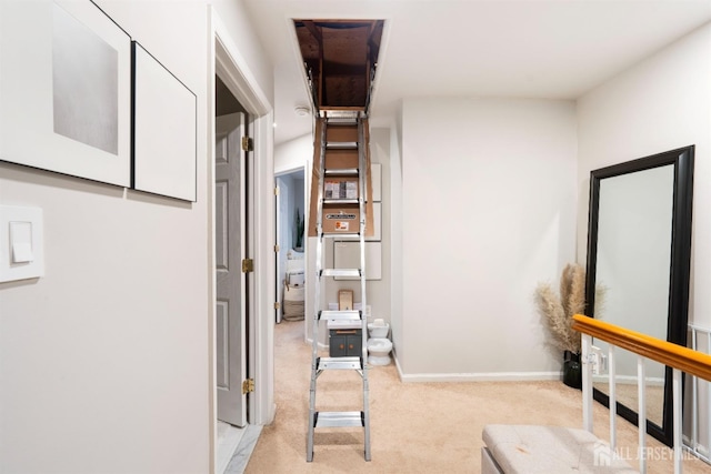 hallway featuring baseboards and light colored carpet