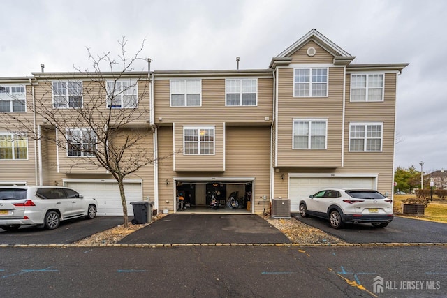 view of property with central AC, driveway, and an attached garage