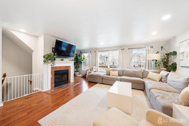 living area with recessed lighting, a fireplace, and wood finished floors