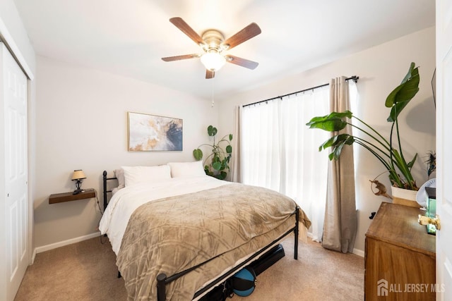 carpeted bedroom with a ceiling fan, baseboards, and a closet