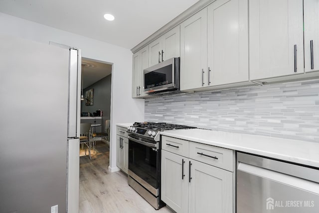324 Oak Knoll Dr, Manalapan, NJ 07726 - kitchen with appliances with stainless steel finishes, light wood-style flooring, decorative backsplash, light countertops, and recessed lighting