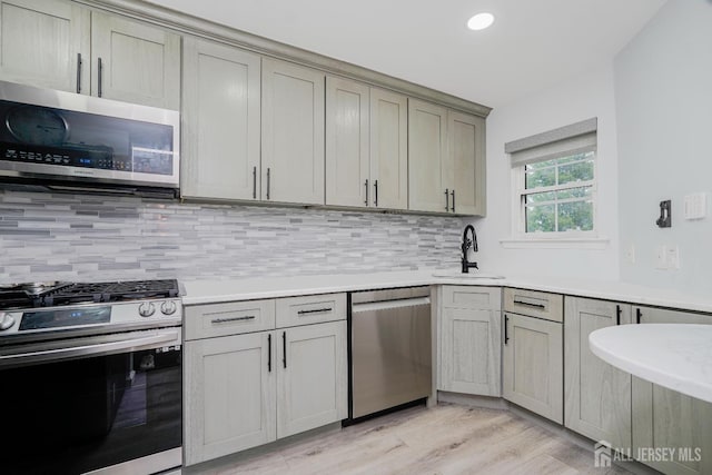 324 Oak Knoll Dr, Manalapan, NJ 07726 - kitchen with stainless steel appliances, tasteful backsplash, light countertops, light wood-type flooring, and gray cabinets