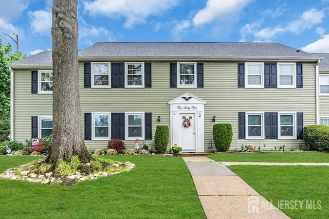 colonial home featuring a front lawn