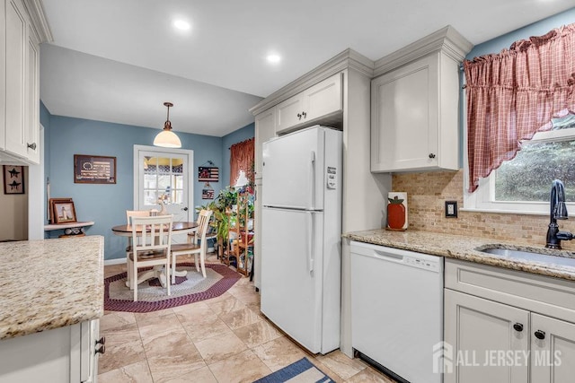 kitchen with white appliances, a sink, tasteful backsplash, decorative light fixtures, and white cabinets