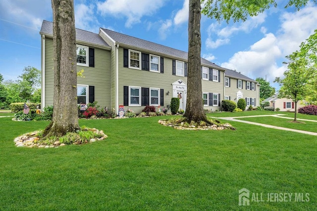 colonial home featuring a front lawn