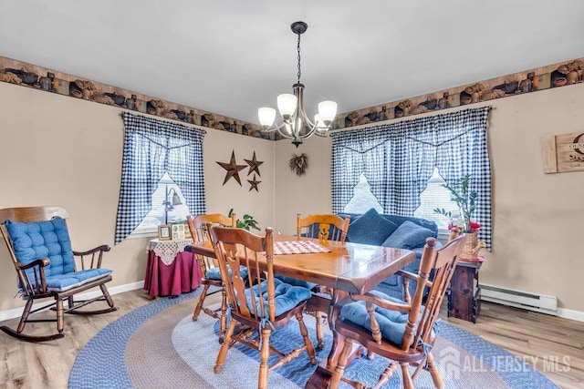 dining area featuring baseboard heating, a chandelier, wood finished floors, and baseboards