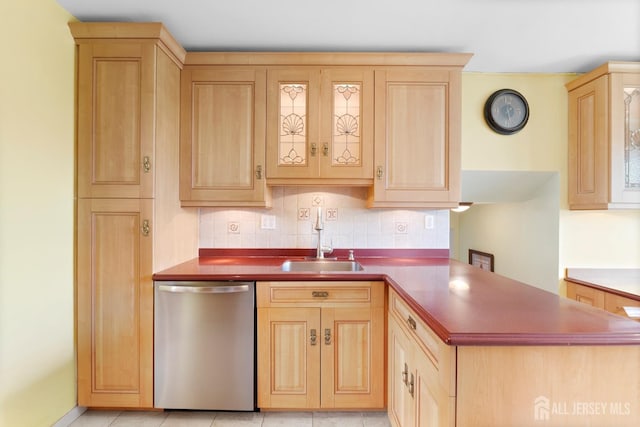 kitchen featuring dishwasher, light brown cabinets, a sink, and a peninsula