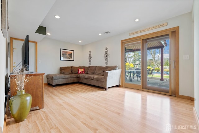 living room featuring light wood-type flooring, baseboards, and recessed lighting