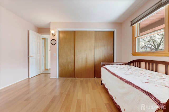 bedroom featuring light wood finished floors and a closet