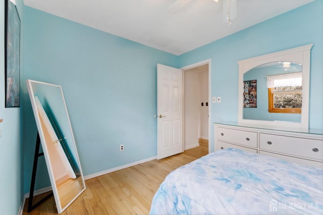 bedroom with light wood finished floors, baseboards, and ceiling fan
