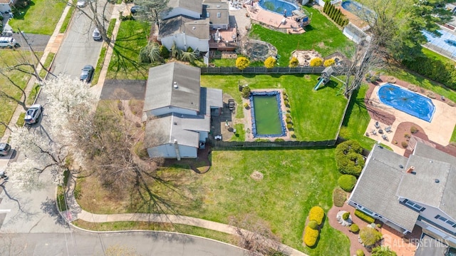 aerial overview of property's location with a pool and nearby suburban area
