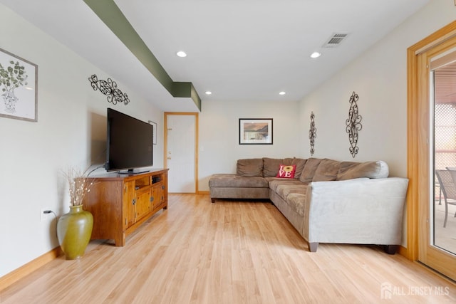 living room featuring light wood-type flooring, baseboards, and recessed lighting