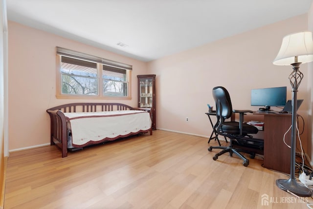 bedroom with wood finished floors and baseboards
