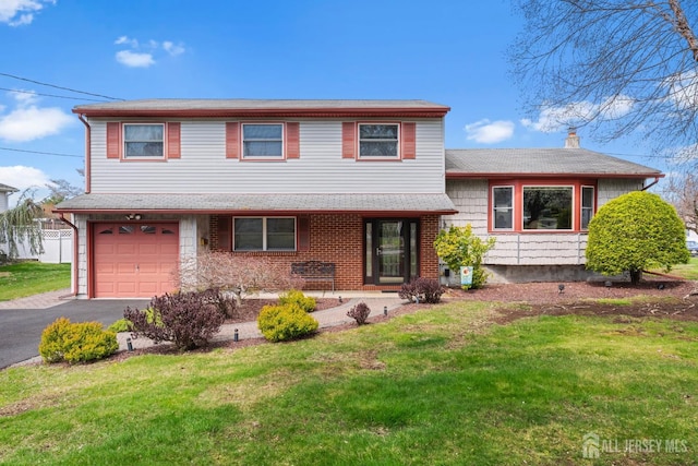 split level home with an attached garage, a front yard, asphalt driveway, a chimney, and roof with shingles